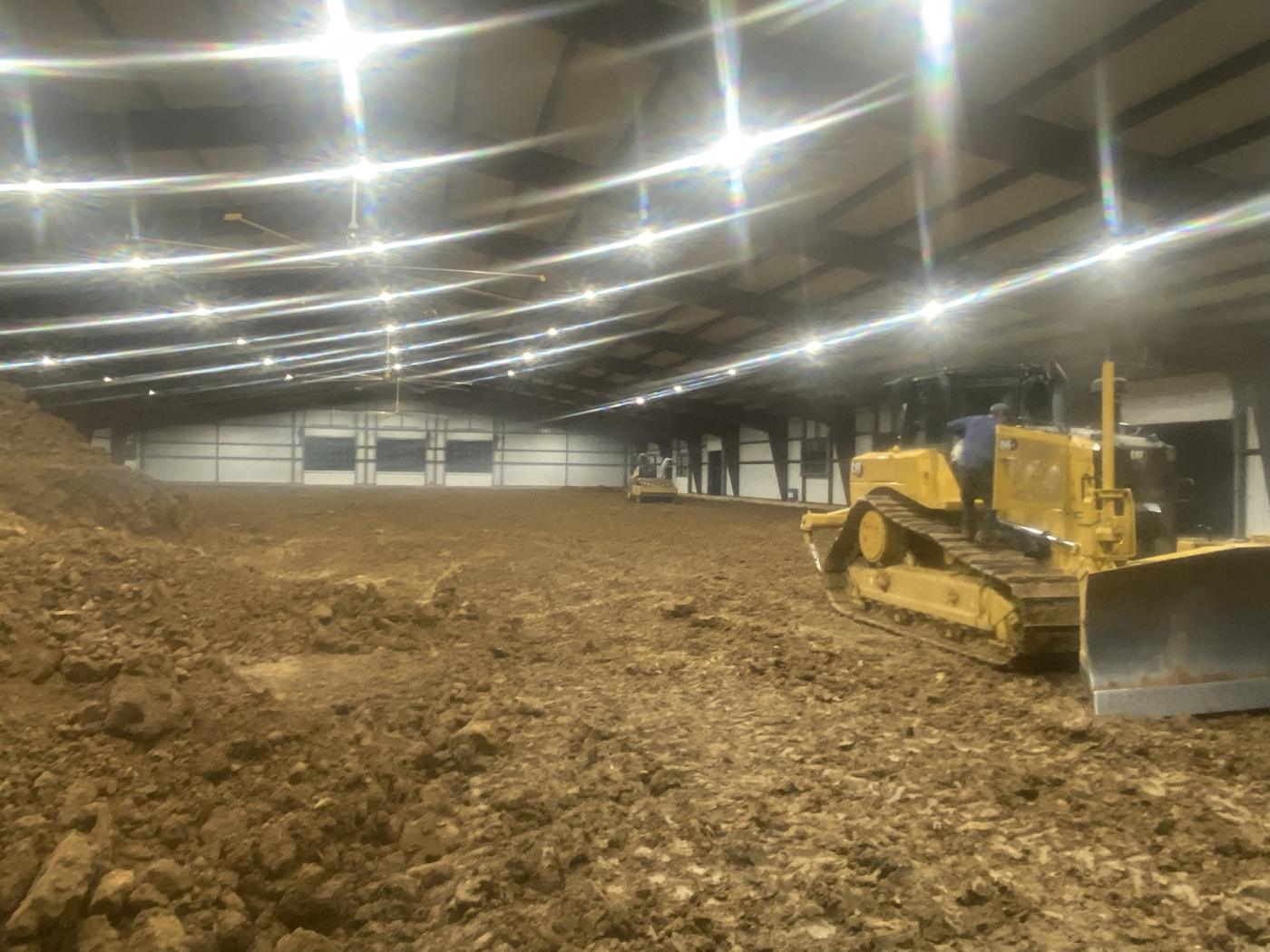 CAT dozer spreading base inside a covered arena